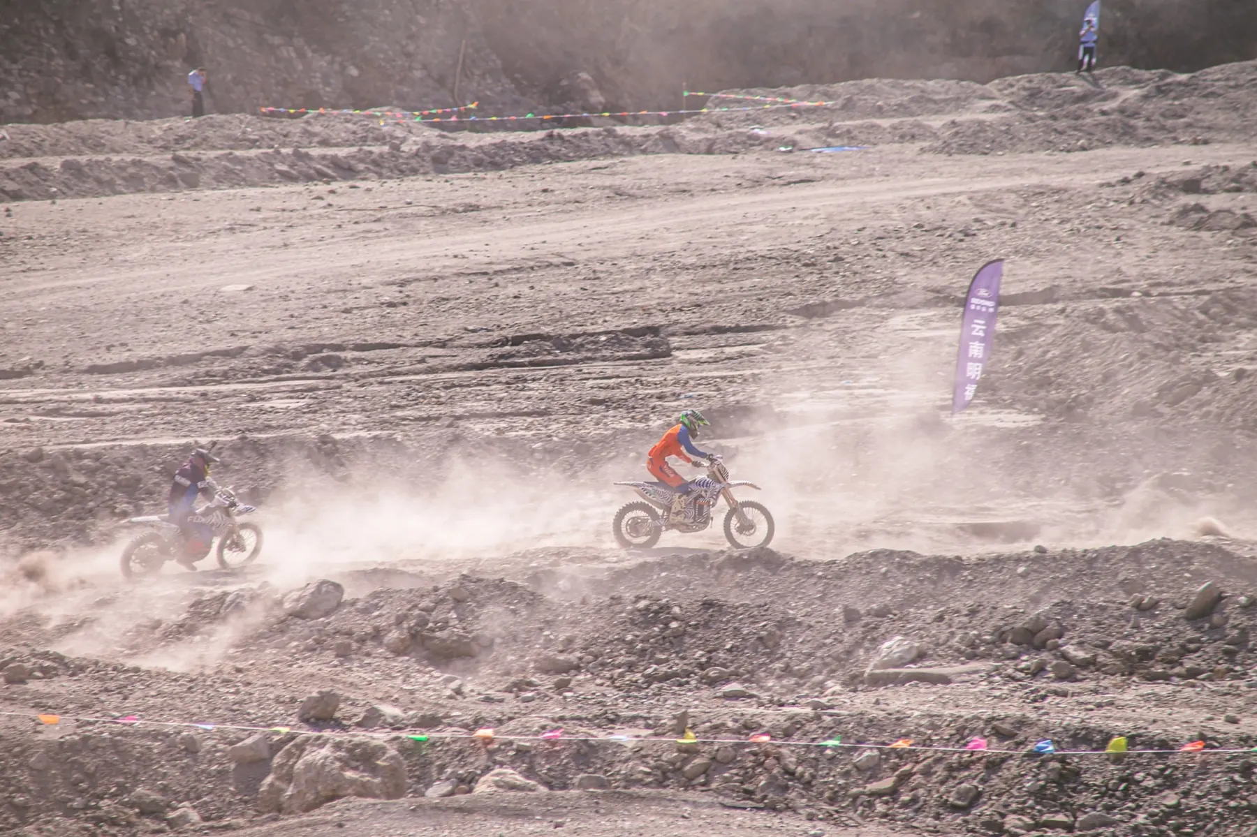 Riders crossing a rugged off-road course