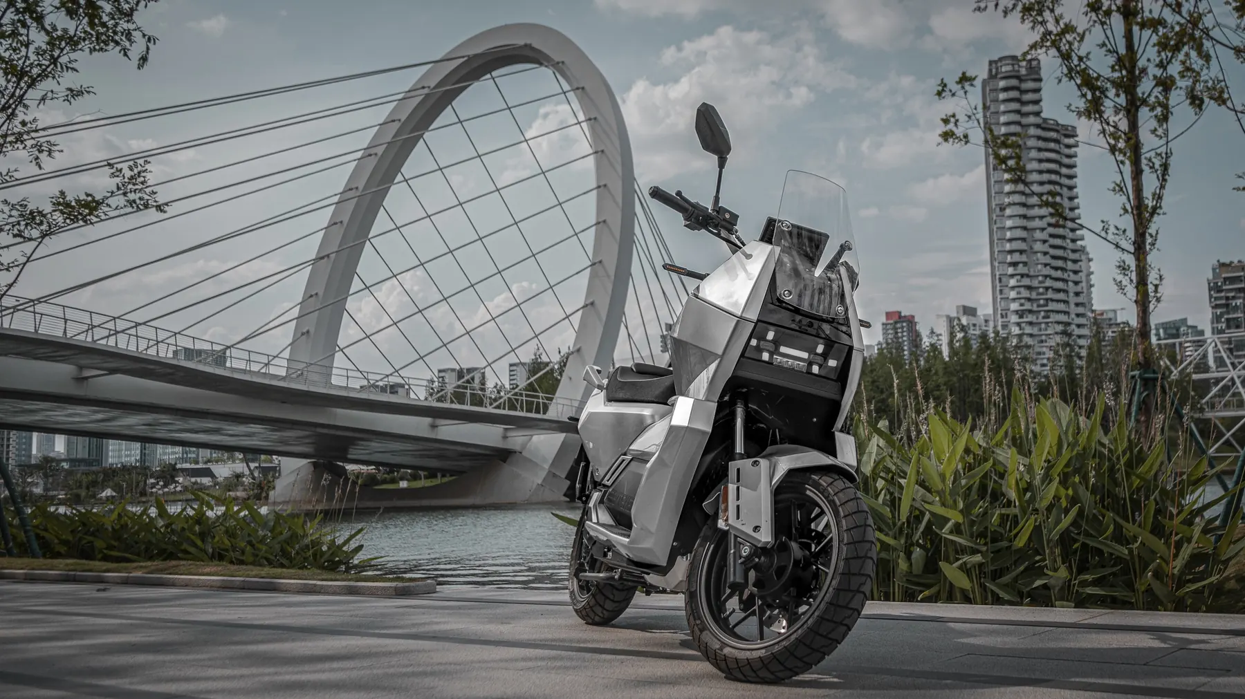 EV01 motorcycle beside a modern city bridge